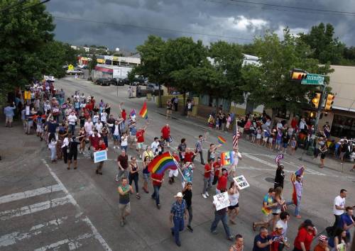 Despite a looming rainstorm, gay couples and their families and friends marched down Cedar Springs Road in Dallas to celebrate the same-sex marriage ruling on Friday, June 26.
