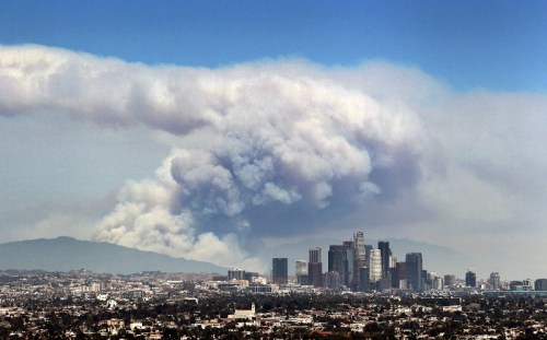 Smoke from wildfires burning in Angeles National Forest filled the sky behind the Los Angeles skyline on June 20, 2016.  Image courtesy of Ringo H.W. Chiu / AP.